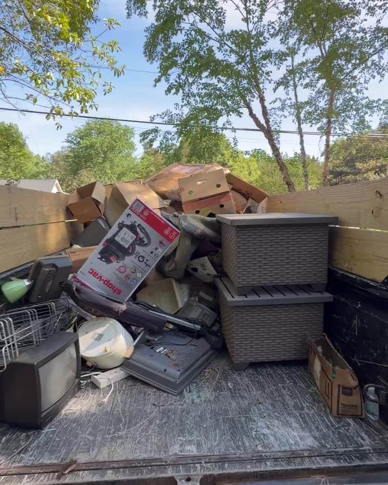 Truck bed loaded with storage totes, boxes and household items from a Charlotte cleanout